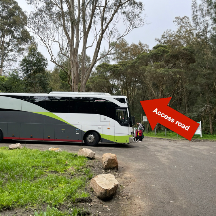 A bus parked in the bus bay with an arrow showing the direction of an access road to Field of Mars EEC.
